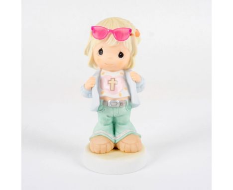 A young girl in green pants, crop top, light blue jacket stands holding her lapels with pink sunglasses on her head.Unglazed 