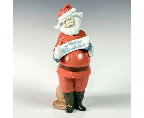 Glossy finish porcelain that is part of Nao by Lladro historical collection. Depicts Santa holding a Merry Christmas sign, wi