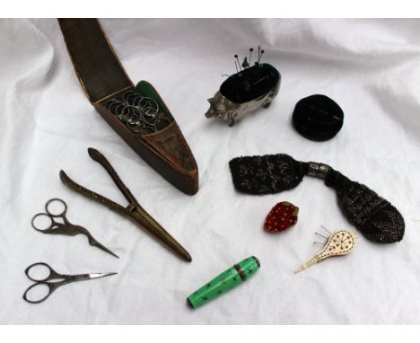 A leather scissor case containing six pairs of scissors, together with other sewing scissors, glove stretchers, electroplated