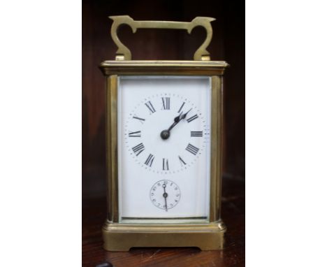 A 19th century French brass carriage clock, the enamel dial with Roman numerals and subsidiary alarm dial, striking on a bell