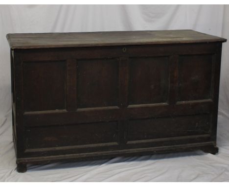 An 18th century oak coffer, the planked rectangular top above a six panelled front on bracket feet, 144cm wide x 56.5cm deep 
