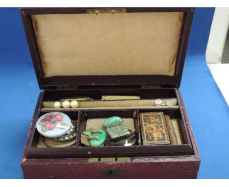 A vintage ox blood leather jewellery box containing a small selection of costume jewellery including an agate pendant, rolled