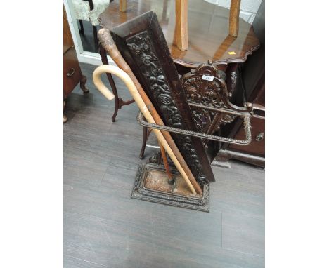 A reproduction cast stick stand, carved panel and sticks