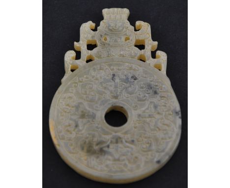 A Chinese nephrite jade pendant in the form of a bi coin