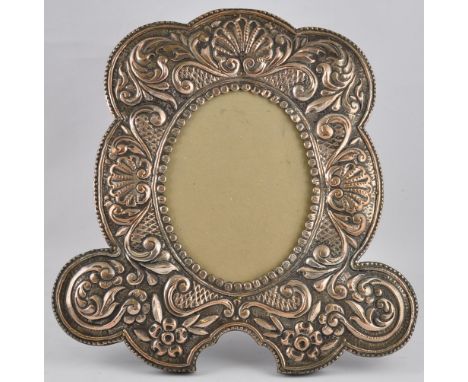 A large late Victorian/early Edwardian silver plated easel photograph frame embossed scallop shells and floral scrolls, h:38c