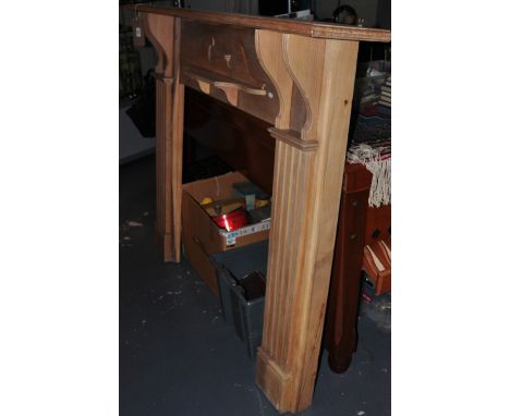 An Edwardian stripped pine and walnut fire surround with swan neck moulding and fluted columns, 166 x 128cms
