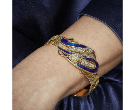 ANNEES 1840BRACELET VOLUTE EMAIL ET DIAMANTSIl est en forme de bracelet rigide ouvrant. Au centre deux fleurs serties de diam