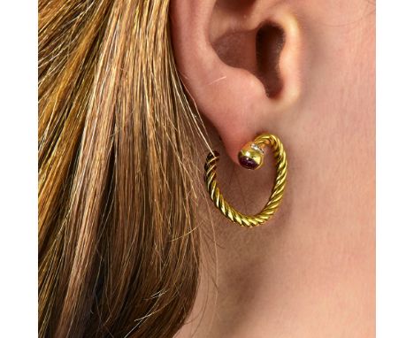 PAIRE DE CREOLES RUBISElles sont en or jaune 18K torsadé terminées par un cabochon de rubis en sertissure. Poids brut : 9,54 