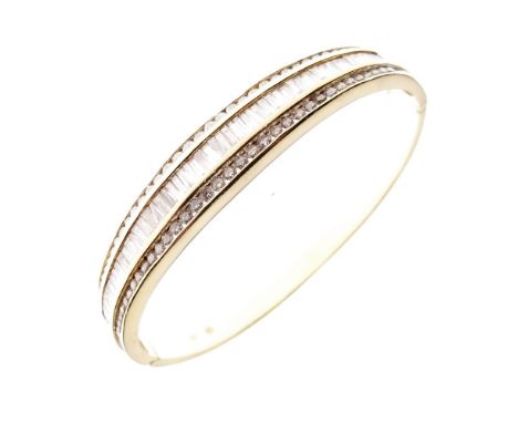Yellow metal and diamond-set snap bangle, the hinged upper section set approximately two baguette-cut diamonds flanked by two