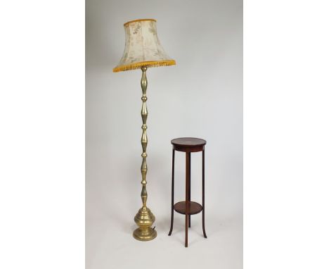 An Indian style brass standard lamp on foliate engraved mirrored baluster column and with cream tasselled shade, column 173cm