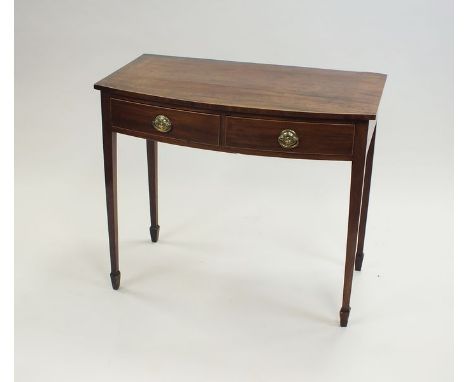 A George III mahogany and boxwood strung side table, the bow front top above two drawers with circular brass stamped swing ha