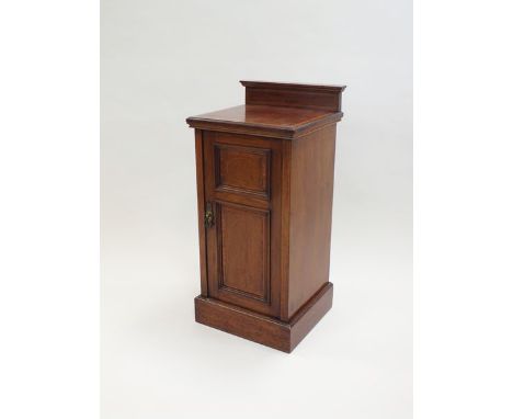 An Edwardian mahogany and satinwood strung bedside cabinet with low gallery back above an indented panel door enclosing a sin