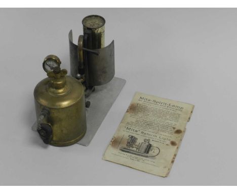 A Mita Lilliput Reford light with wing nut pressure valve and gauge above a brass fuel chamber, pipes mantel and reflector on