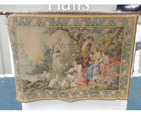 An 18th century style tapestry wall hanging, machine woven, worked with a scene of a rustic boy and three maidens in a bucoli