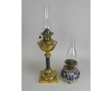 A brass candlestick oil lamp and another earthenware example. (2)