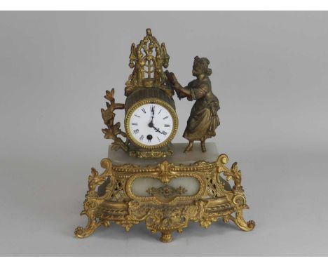 A French gilt metal and alabaster mantel clock, the fluted barrel beside a maiden reading from a book above a shaped rococo b