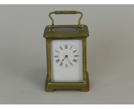 A French brass carriage timepiece, first half 20th century, of typical form, the white enamel dial with black Roman numerals,