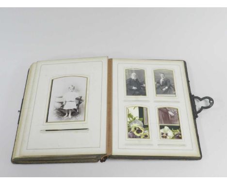 An Edwardian photograph album, leather bound, the leaves printed with flower sprays and gilt-edged photo mounts, partially fi