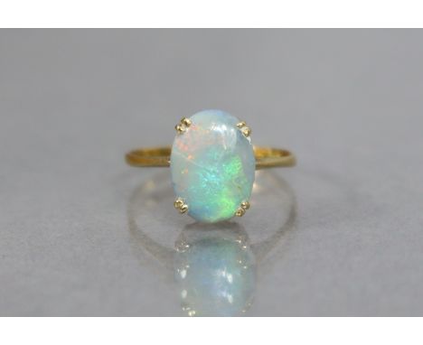 An opal ring, the oval stone measuring approx. 12mm x 8mm, set to a yellow metal shank marked “18ct”; size: P/Q; weight: 2 gm