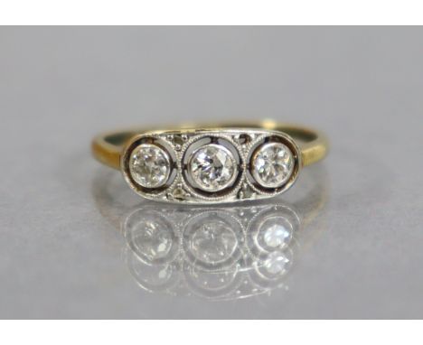 An 18ct. gold &amp; platinum ring set three small diamonds within open circles, tiny rose diamonds in between (one rose diamo