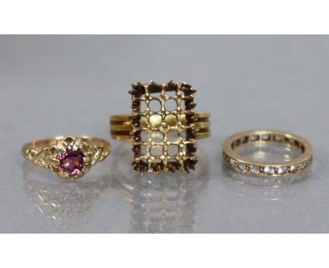 A yellow metal ring set circular amethyst, with pierced scroll shoulders, the shank marked “18”, size: K; weight: 2 gm; a 9ct
