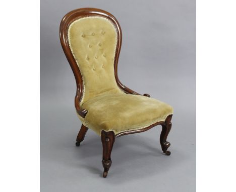 A Victorian mahogany-frame spoon-back nursing chair, upholstered yellow velour, on carved cabriole legs with ceramic castors,