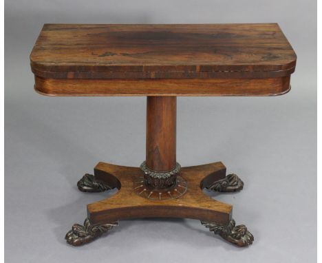 A Regency rosewood card table with rounded corners to the rectangular fold-over top, inset red baize to one side, on plain ce