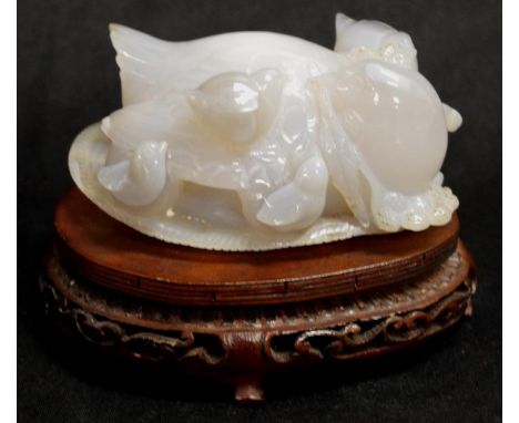 Chinese carved jade figure of a Quail with chick on her back, together with a timber stand. 13cm wide.