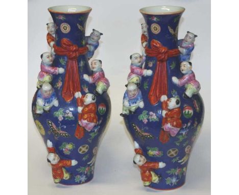 Two large vintage Chinese blue vases decorated with porcelain figures of climbing boys. Red seal mark to base. 46cm high.