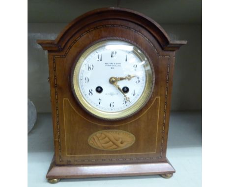 An Edwardian satinwood inlaid mahogany mantel clock; the 8 day movement faced by an enamelled Arabic dial, inscribed Milford 
