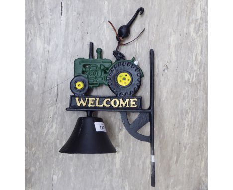 A cast iron door bell, fashioned as a tractor, on a wall bracket  13''h       CA