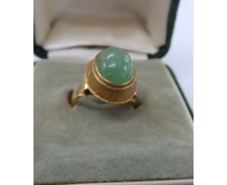 A yellow metal ring, set with a jade stone and engine turned decoration  boxed       11