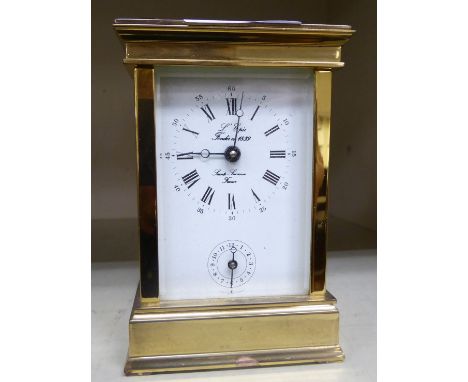 A modern lacquered brass carriage clock with bevelled glass panels and a swing top handle  inscribed 'Saint Sukanne'  5''h   