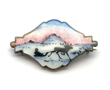 An Ivar Holth silver and enamel brooch depicting a reindeer pulling a figure on a sledge. Stamped 'Sterling Norway' on revers