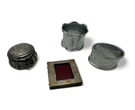 Two hallmarked silver napkin rings, one with Chester 1906 halllmarks, a white metal trinket box, and small silver photo frame