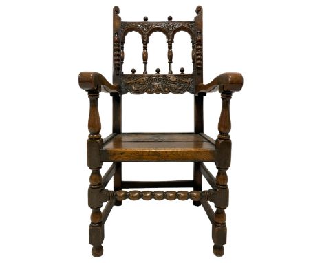 17th century design oak armchair, the back carved with trailing foliage and with turned spindle supports, the uprights mounte