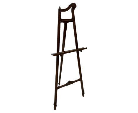 Edwardian mahogany easel, the moulded frame decorated with acanthus leaf scrolls, decorated with carved foliage, terminating 