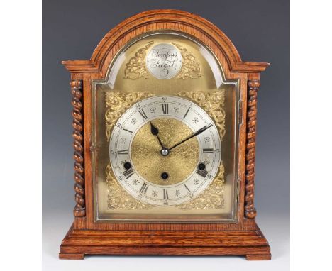 A George V oak mantel clock with eight day movement striking and chiming on gongs, the brass breakarch dial with silvered 'Te