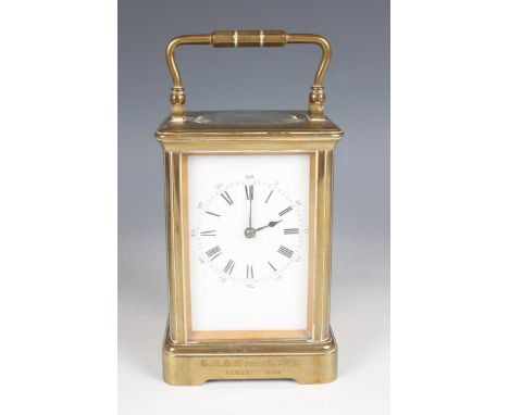 A late 19th century French brass corniche cased carriage clock with eight day movement striking on a gong, the white enamelle