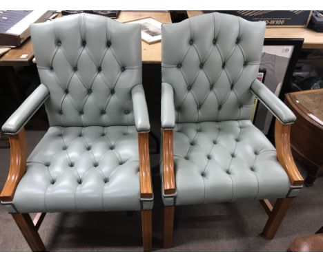 A set of four open arm chairs with green leather  button back and seat on square tapering legs and a matching two seater sofa