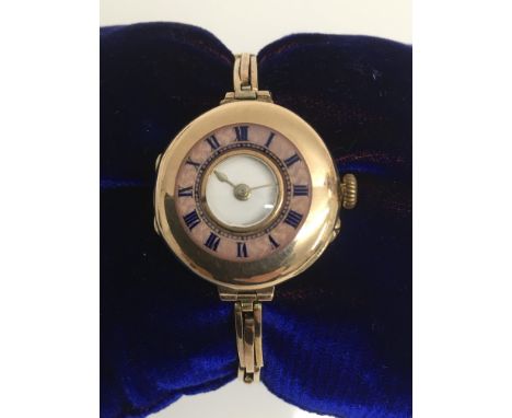 A lady's vintage gold wristwatch with enamel Roman Numeral dial