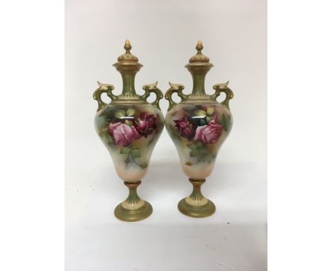 A pair of Royal Worcester twin handle  vases with detachable lids decorated with roses signed W J Martin 32 cm