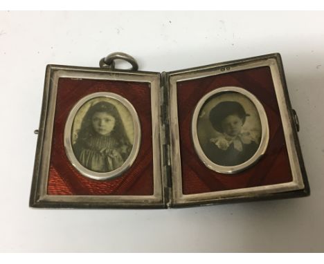 A quality silver and enamel photo frame the case enclosing two ovals with red enamel. Chester hallmarks. Size 5x4cm.