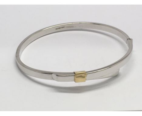 A 9ct, two colour gold hinged bangle, 8.2.gr