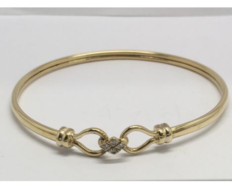 A 9ct gold, diamond set hook bangle, 5.7gr.