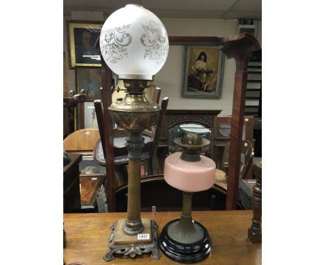 A Victorian brass and alabaster oil lamp with shade and a Victorian oil lamp on brass base with pink china reservoir.