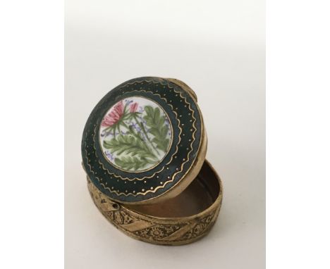 A gilt metal and enamel patch box with mirrored interior