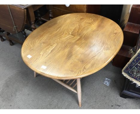 A blonde Ercol Occasional table the splayed legs united by an open magazine rack 100x83cm.