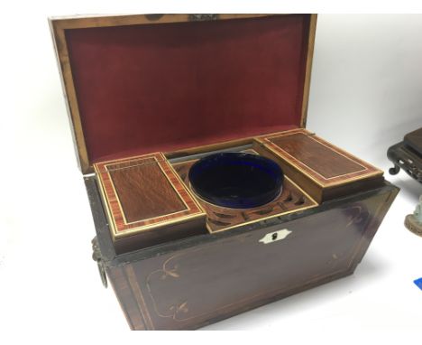 A Regency inlaid Mahogany tea caddy with a domed top the sides with applied lion mask handles with a well fitted interior. 34