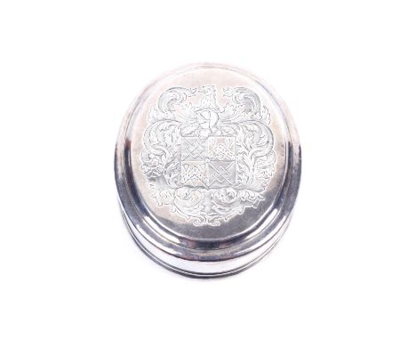 A Queen Anne britannia standard silver oval tobacco box. With plain moulded borders, the pull-off cover engraved with a crest
